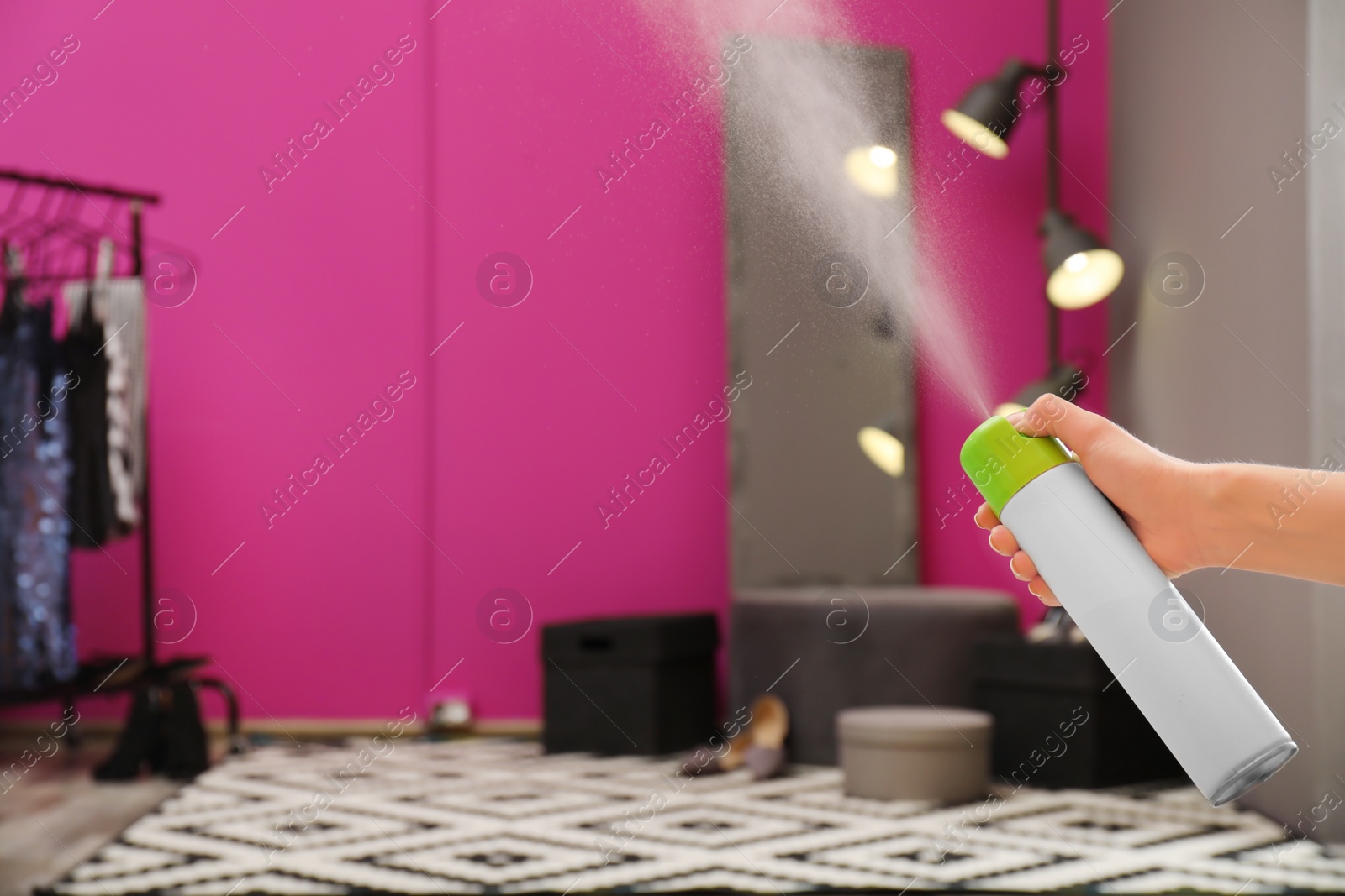 Photo of Woman spraying air freshener at home