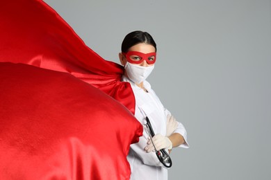 Doctor dressed as superhero posing on white background. Concept of medical workers fighting with COVID-19