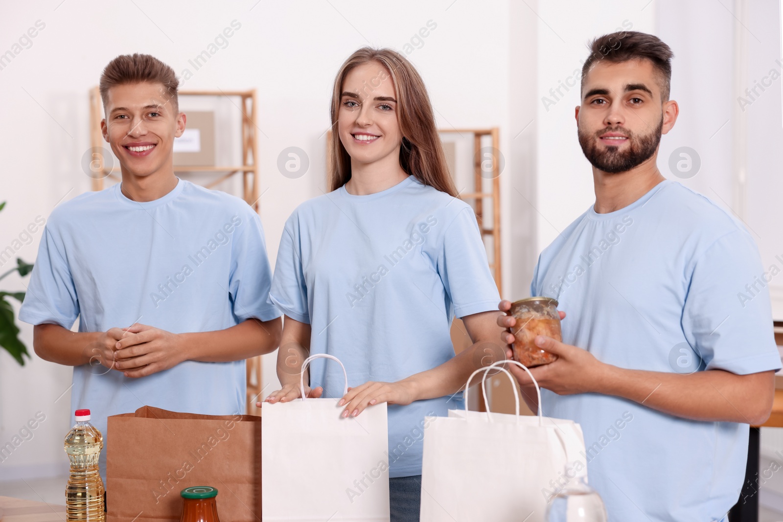 Photo of Portrait of volunteers packing food products indoors