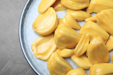 Delicious exotic jackfruit bulbs on grey table, top view