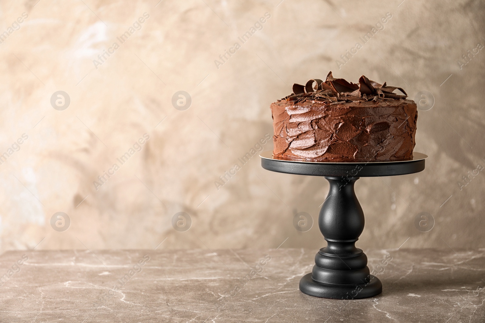 Photo of Stand with tasty homemade chocolate cake on table. Space for text