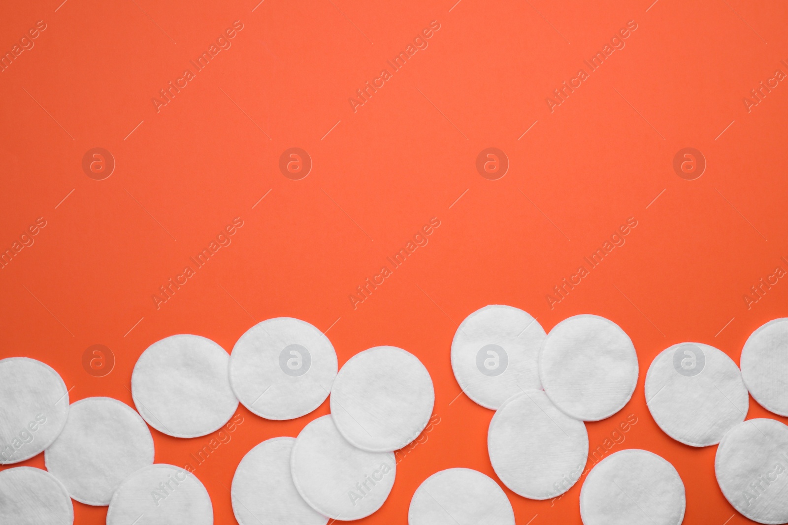 Photo of Many clean cotton pads on orange background, flat lay. Space for text