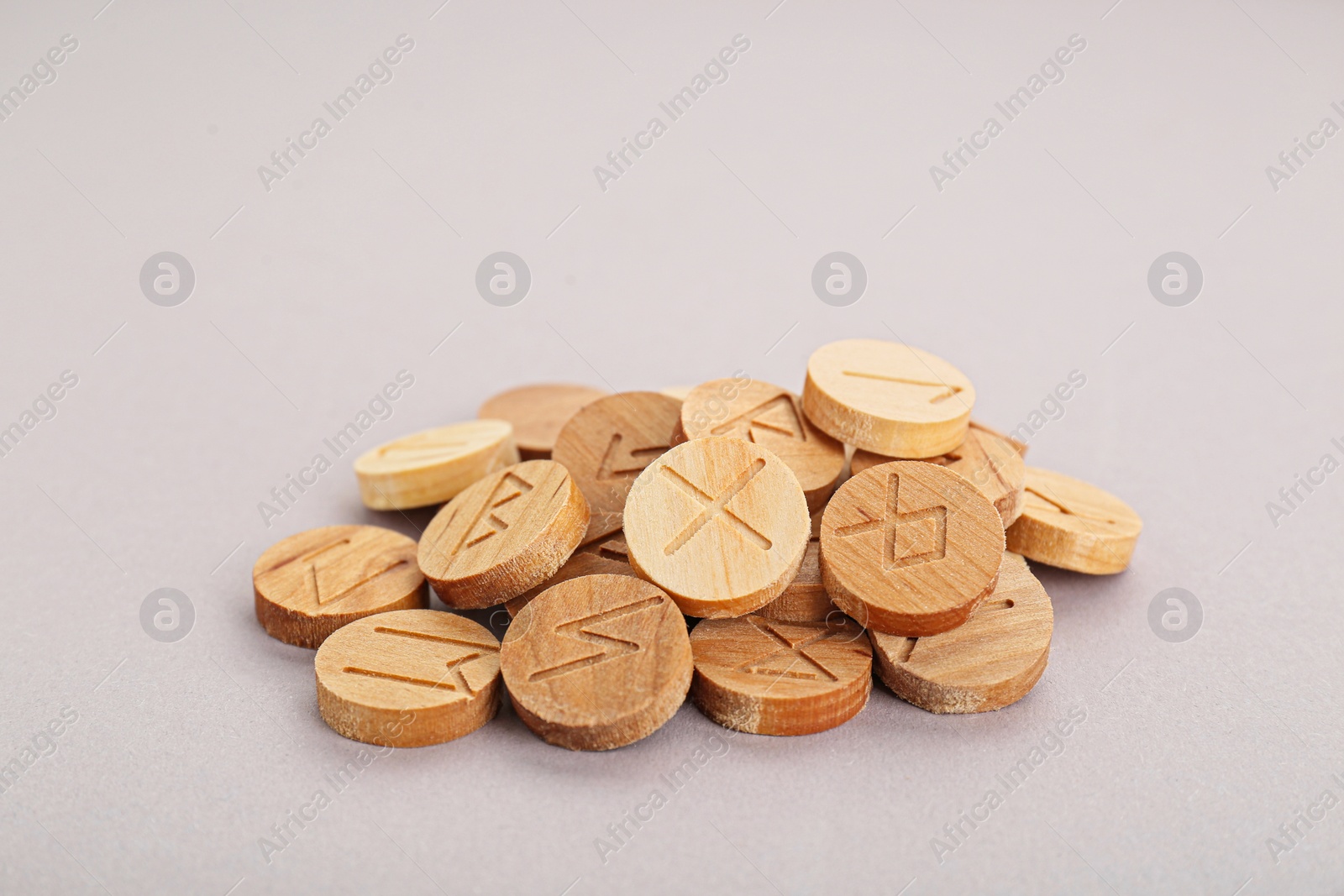 Photo of Pile of wooden runes on light grey background