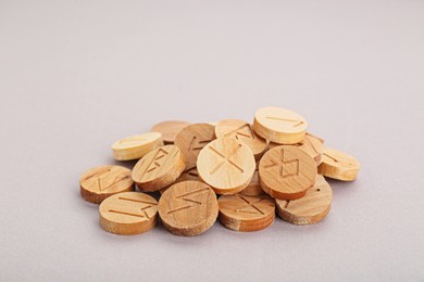 Pile of wooden runes on light grey background