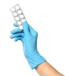 Scientist in protective gloves holding pills on white background, closeup