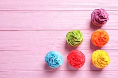 Photo of Delicious birthday cupcakes on wooden background