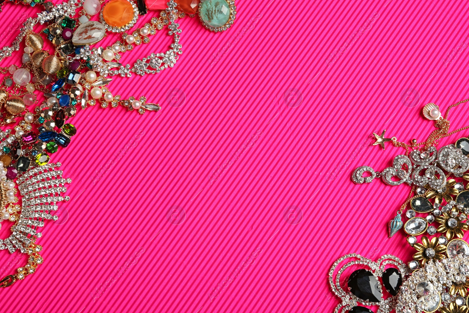 Photo of Frame made of different jewelry on pink background, above view. Space for text