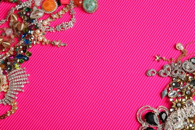Photo of Frame made of different jewelry on pink background, above view. Space for text