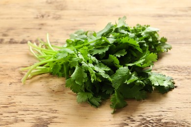 Photo of Bunch of fresh aromatic cilantro on wooden table