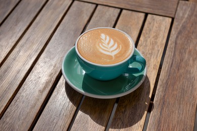 Photo of Cup of aromatic hot coffee on wooden table