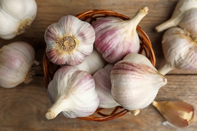 Photo of Fresh organic garlic on wooden table, flat lay