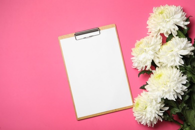 Photo of Blank clipboard and chrysanthemum flowers on pink background, flat lay. Teacher's day