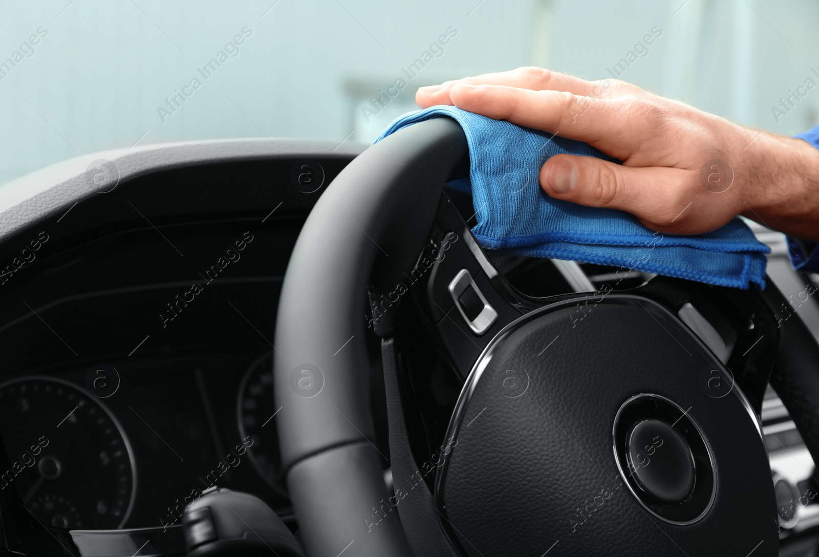 Photo of Car wash worker cleaning automobile interior, closeup