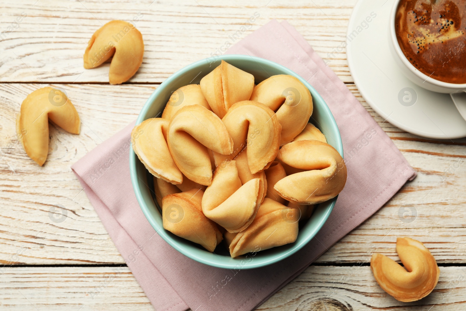 Photo of Tasty fortune cookies with predictions on white wooden table, flat lay