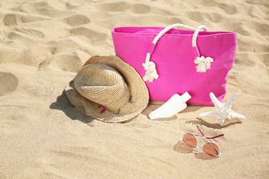 Photo of Stylish beach accessories on sand near sea