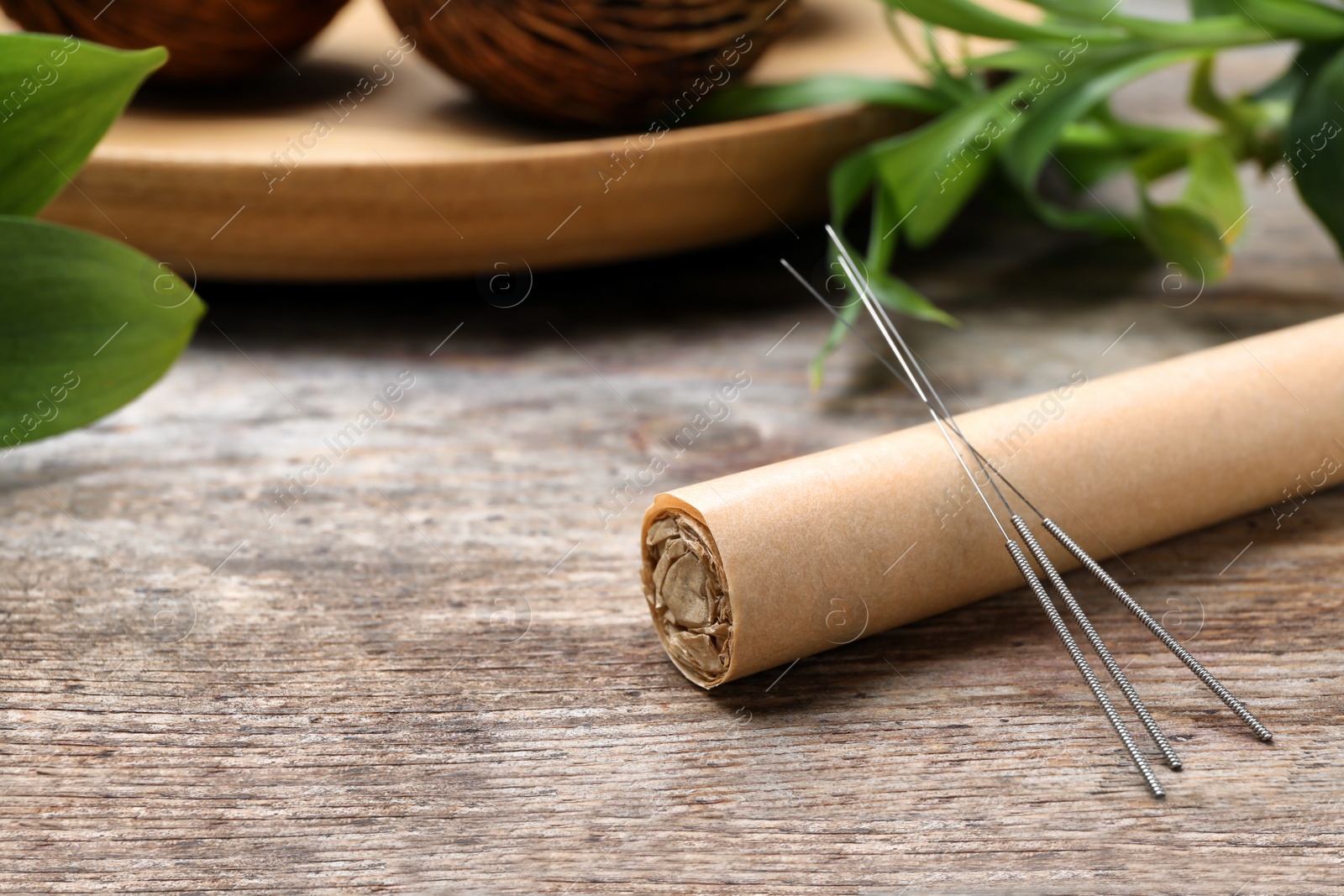 Photo of Moxa stick with needles for acupuncture on wooden table