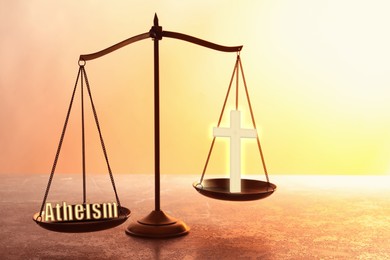 Choice between atheism and religion. Scales with word and cross on textured surface