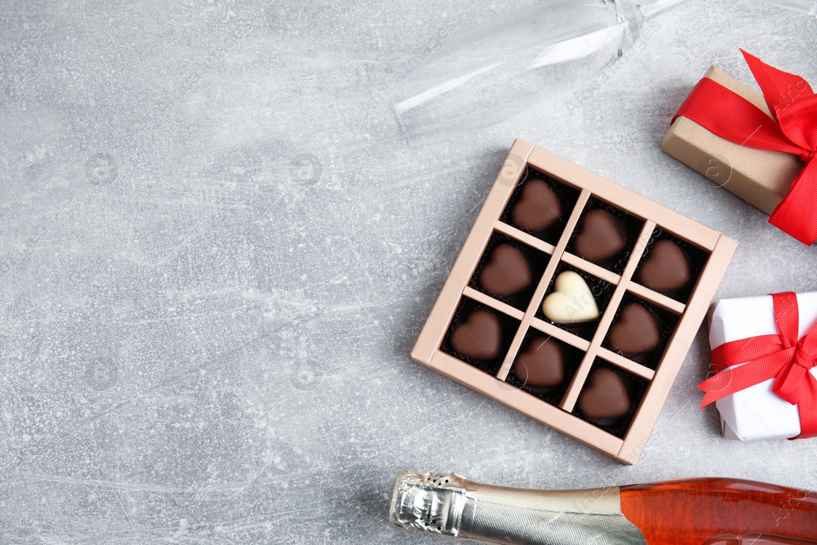 Photo of Flat lay composition with heart shaped chocolate candies on light grey table, space for text. Happy Valentine's day