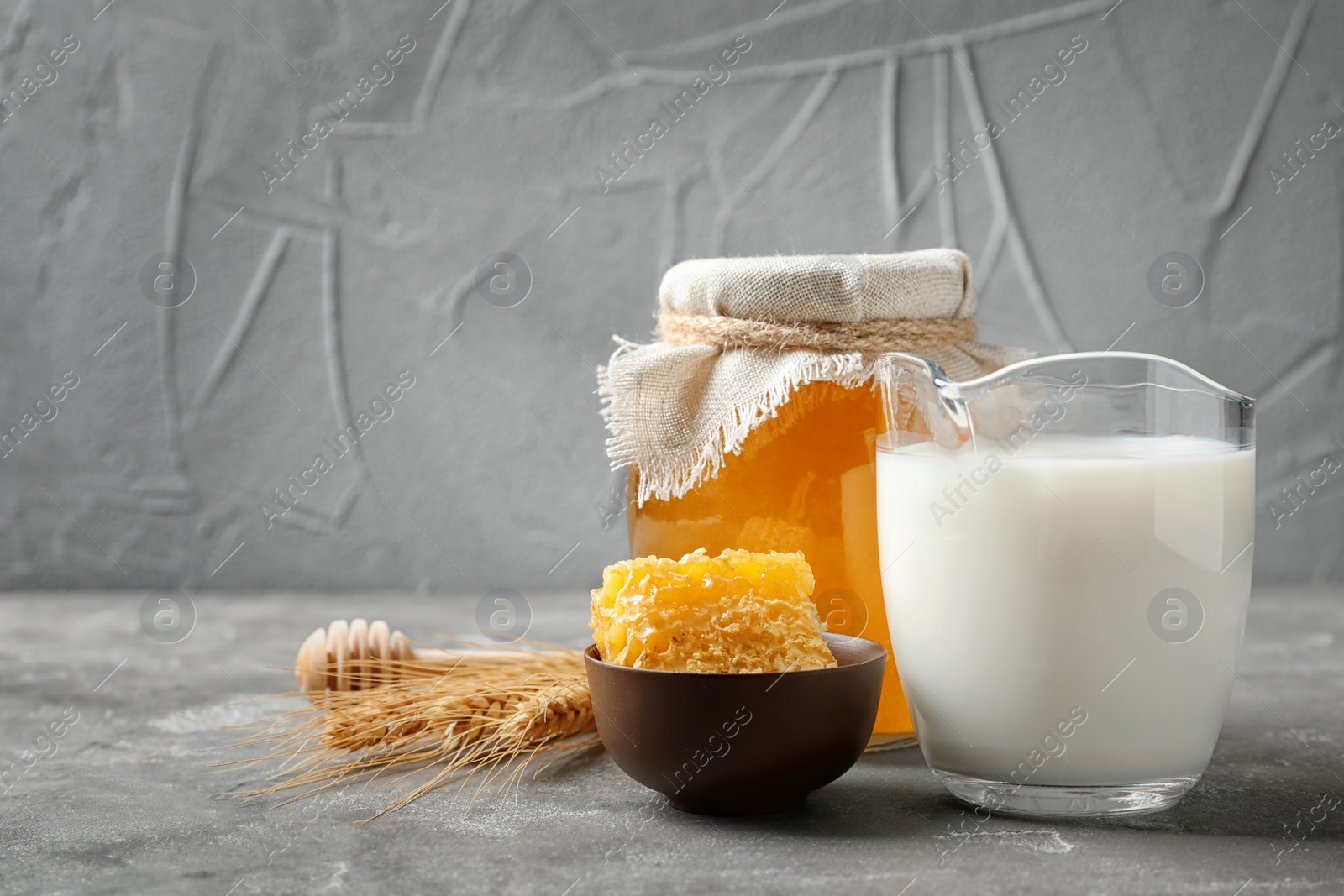 Photo of Beautiful composition with milk and honey on grey table