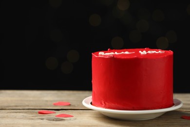 Photo of Bento cake covered with red cream on wooden table, space for text. St. Valentine's day surprise