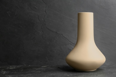 Stylish empty ceramic vase on black table, space for text