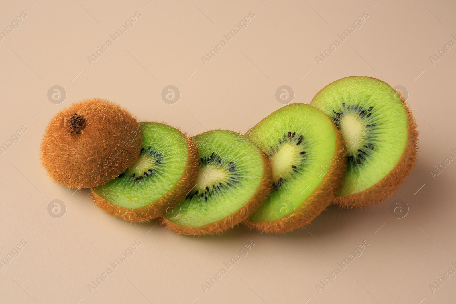 Photo of Sliced fresh ripe kiwi on beige background