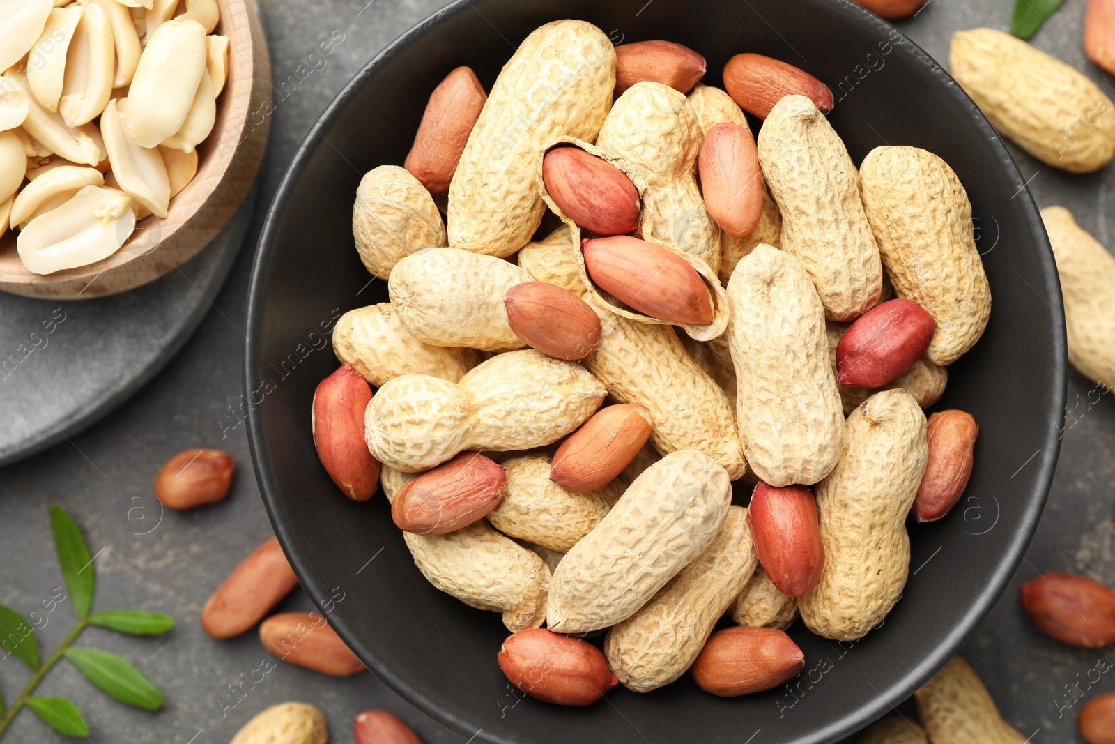 Photo of Fresh peanuts and twig on grey table, flat lay