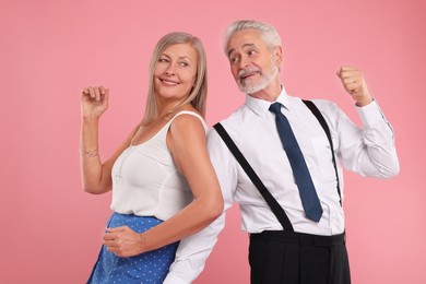 Photo of Senior couple dancing together on pink background