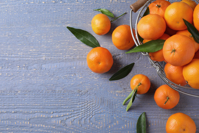 Photo of Fresh ripe tangerines on grey wooden table, flat lay. Space for text