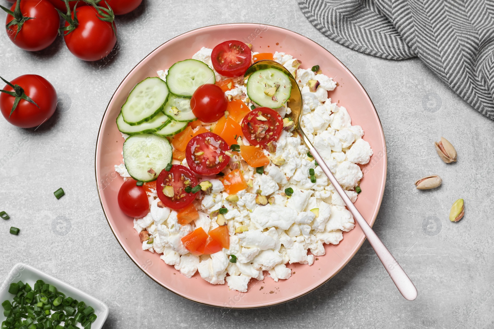 Photo of Delicious cottage cheese with vegetables served for breakfast on light grey table, flat lay