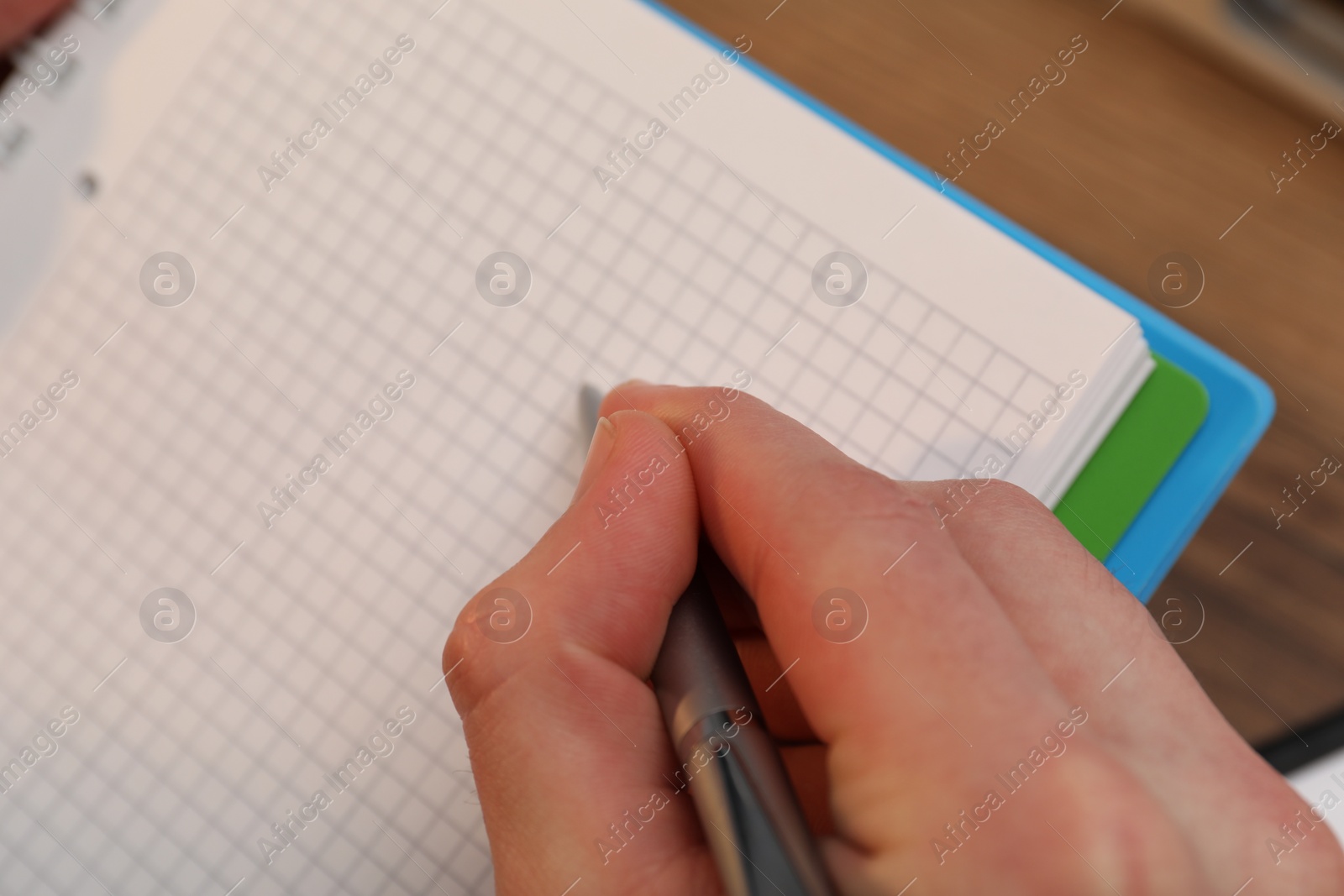 Photo of Man taking notes at table, closeup view