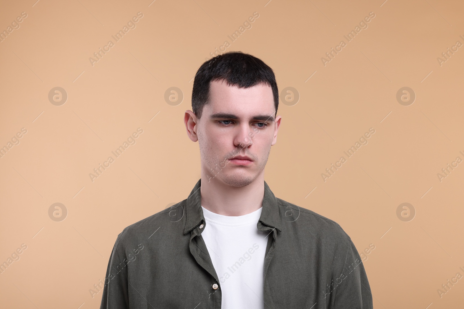 Photo of Portrait of sad man on beige background