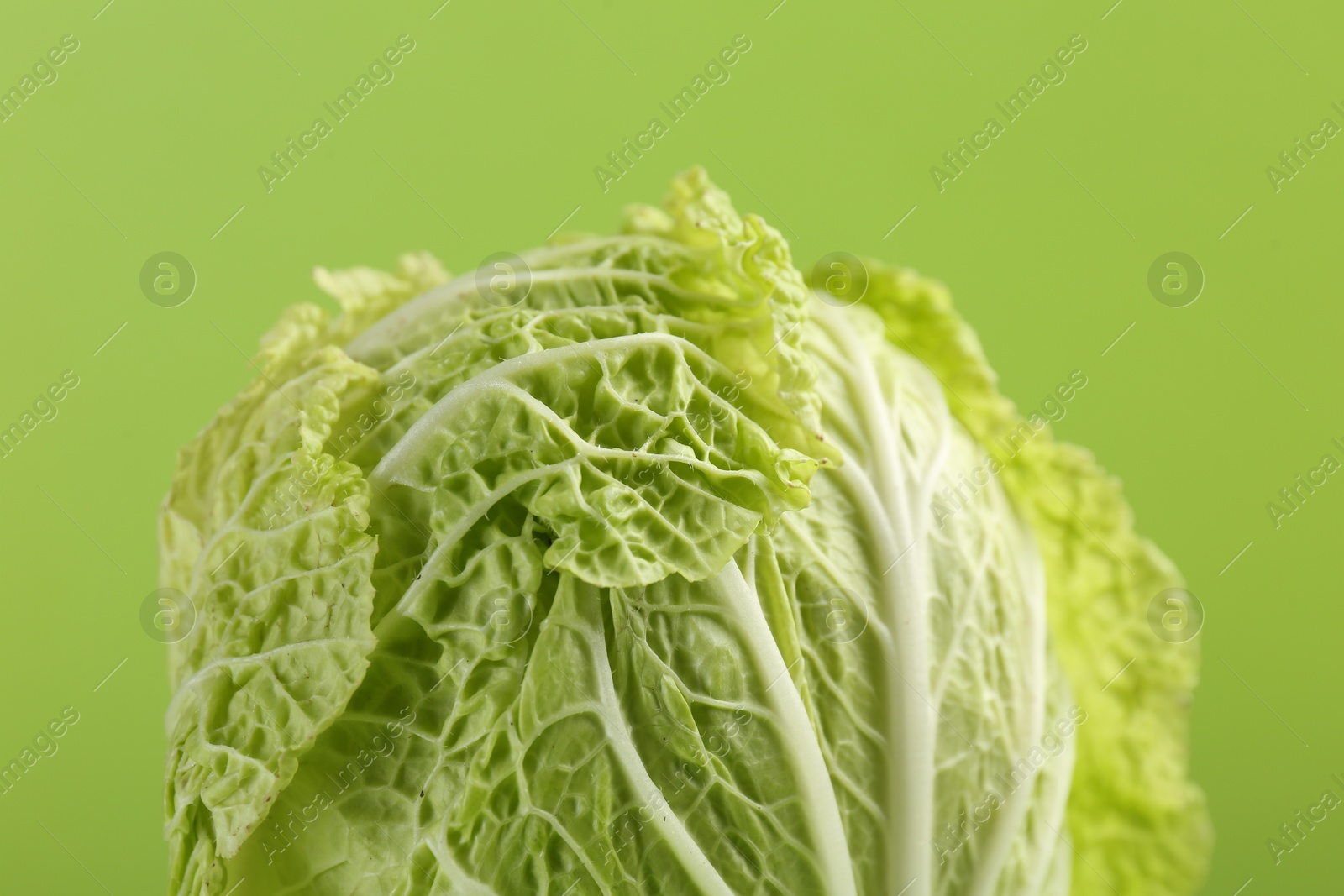 Photo of Fresh ripe Chinese cabbage on light green background, closeup