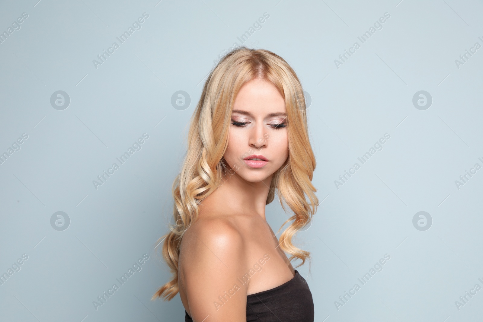 Photo of Beautiful woman with healthy long blonde hair on light background