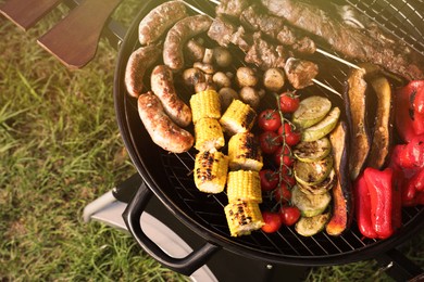 Tasty meat and vegetables on barbecue grill outdoors, top view