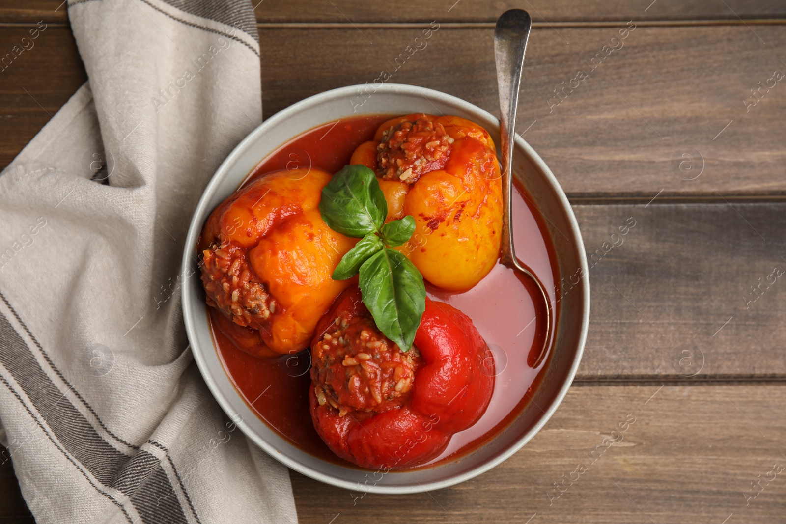 Photo of Delicious stuffed peppers served on wooden table, flat lay