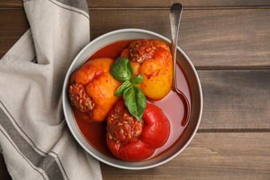 Photo of Delicious stuffed peppers served on wooden table, flat lay