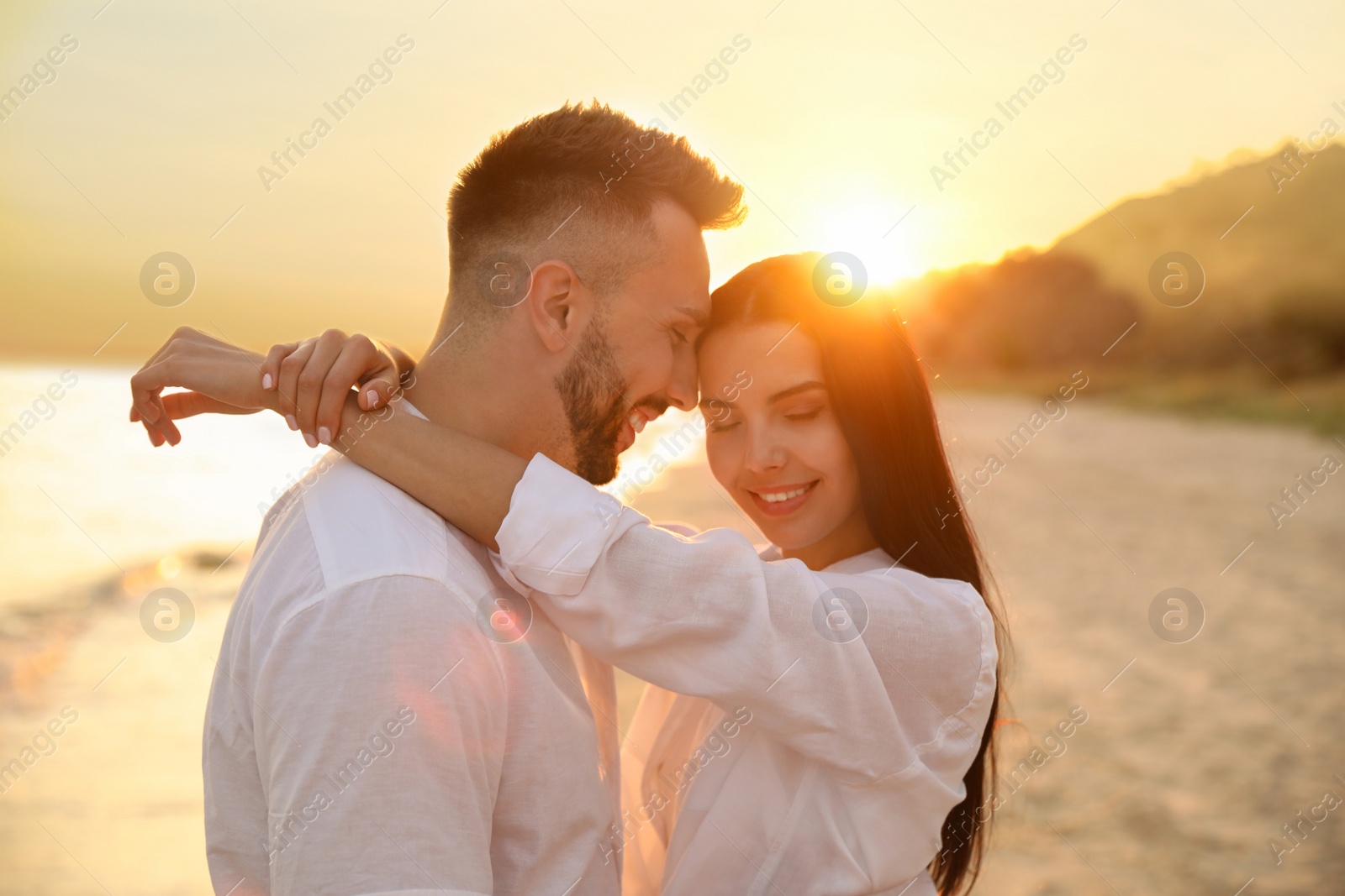 Photo of Happy young couple on beach at sunset