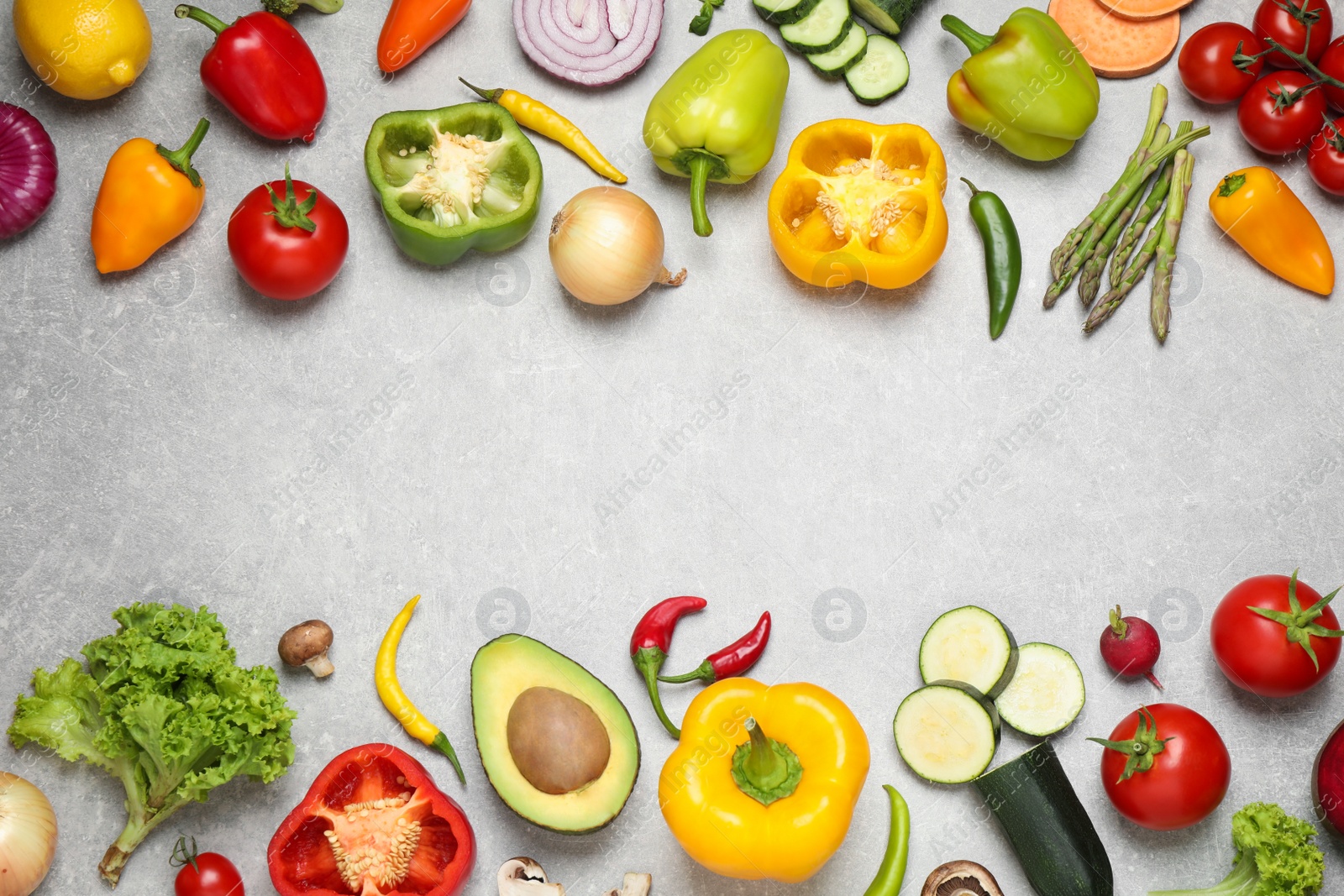 Photo of Frame of fresh vegetables on grey table, flat lay. Space for text