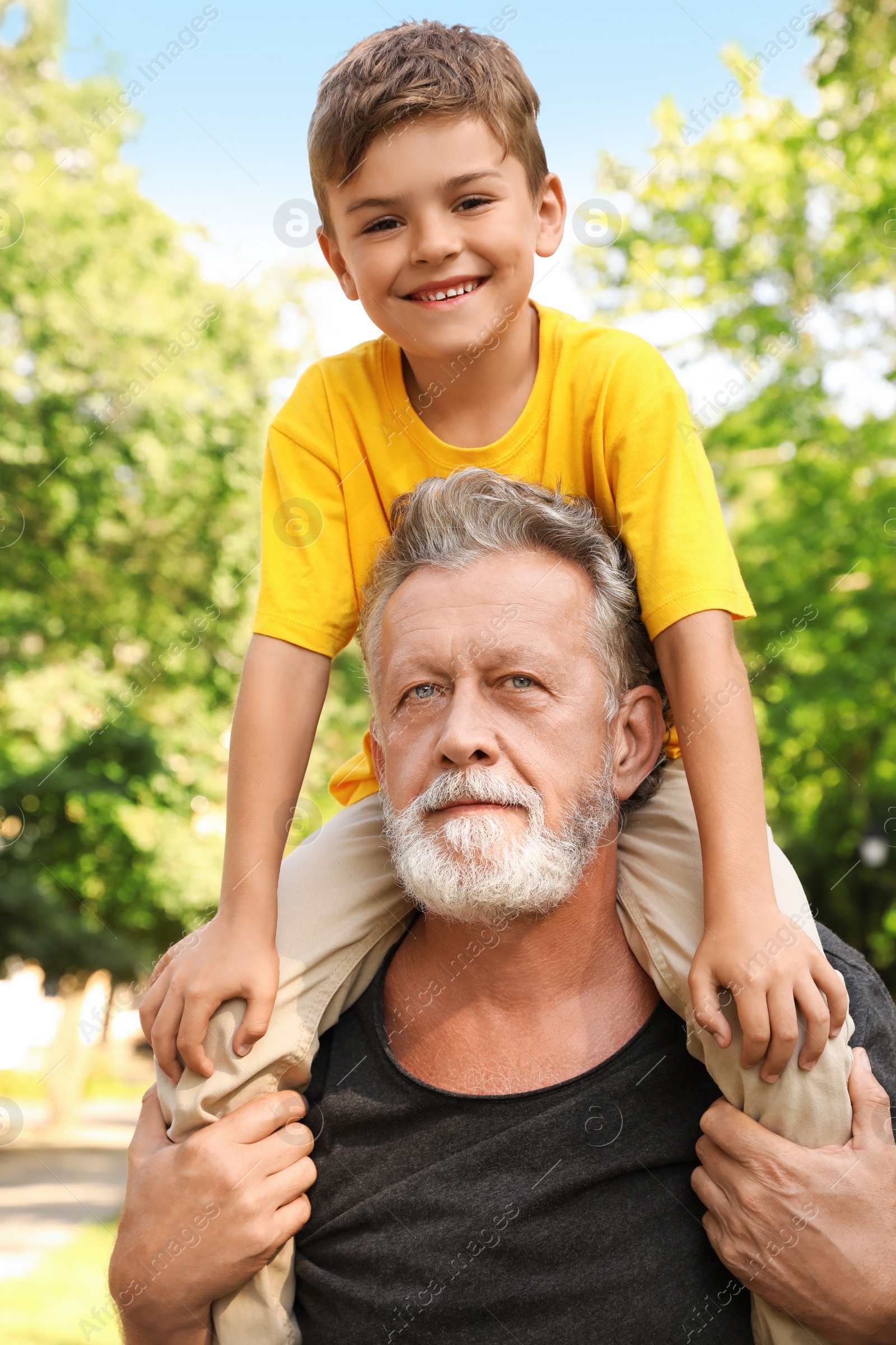 Photo of Senior man with his little grandson in park