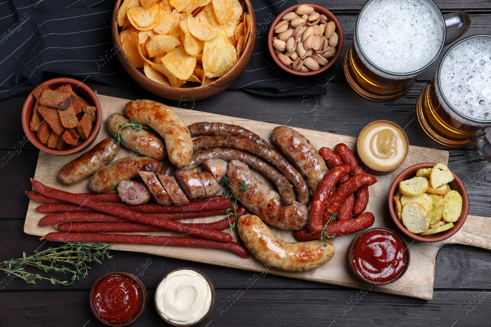 Photo of Set of different tasty snacks and beer on wooden table, flat lay