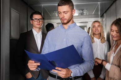 Group of office workers in modern elevator