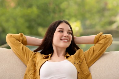 Teenage girl relaxing on sofa at home