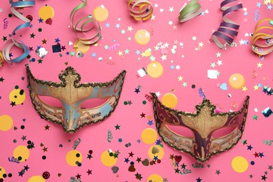 Photo of Beautiful carnival masks and party decor on pink background, flat lay