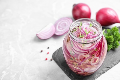 Photo of Jar of pickled onions on marble table. Space for text