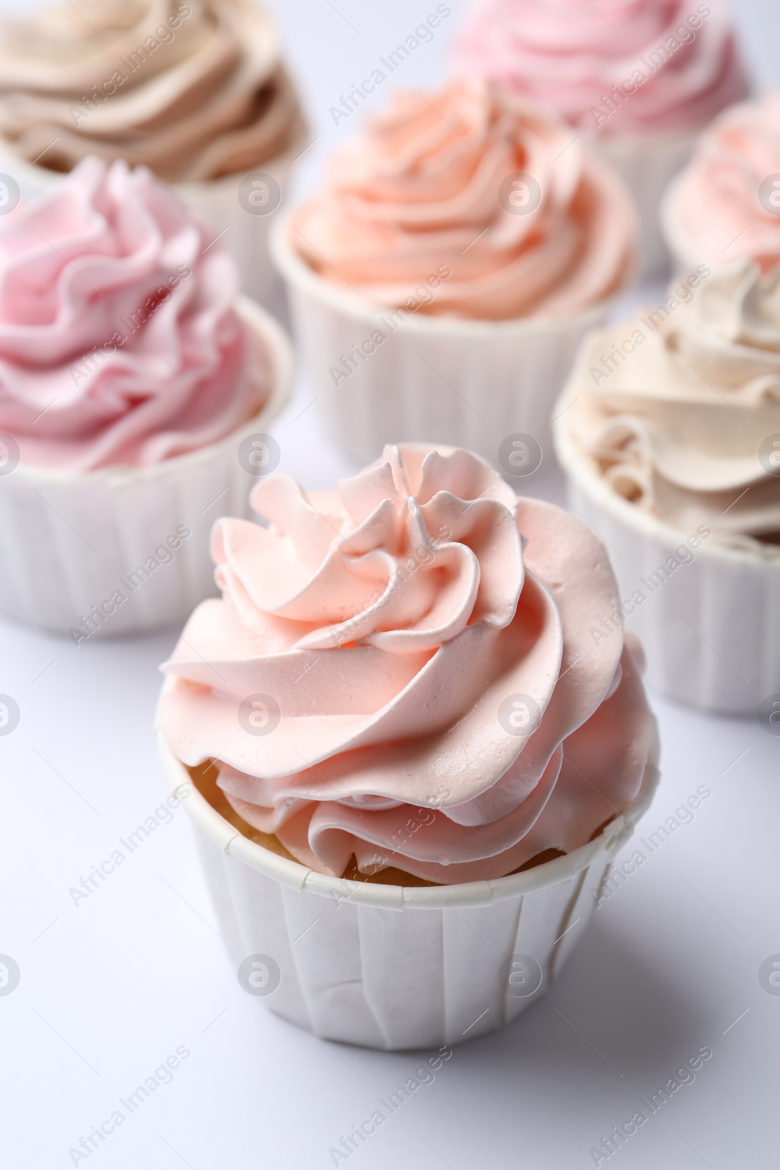 Photo of Many tasty cupcakes on white background, closeup