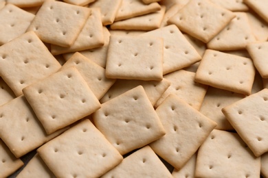Many delicious crackers as background, closeup view