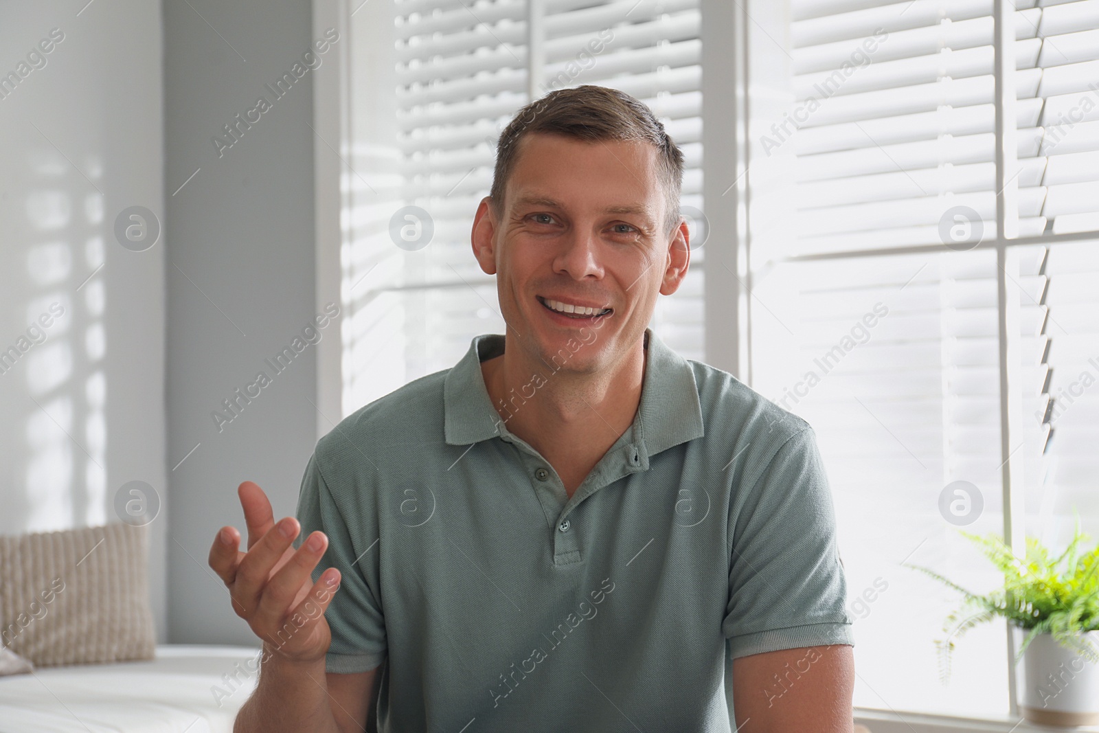 Photo of Man talking to his coworkers through video conference indoors, view from webcam