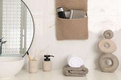 Photo of Knitted organizer hanging on wall in bathroom