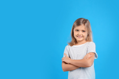Photo of Cute little girl on light blue background. Space for text